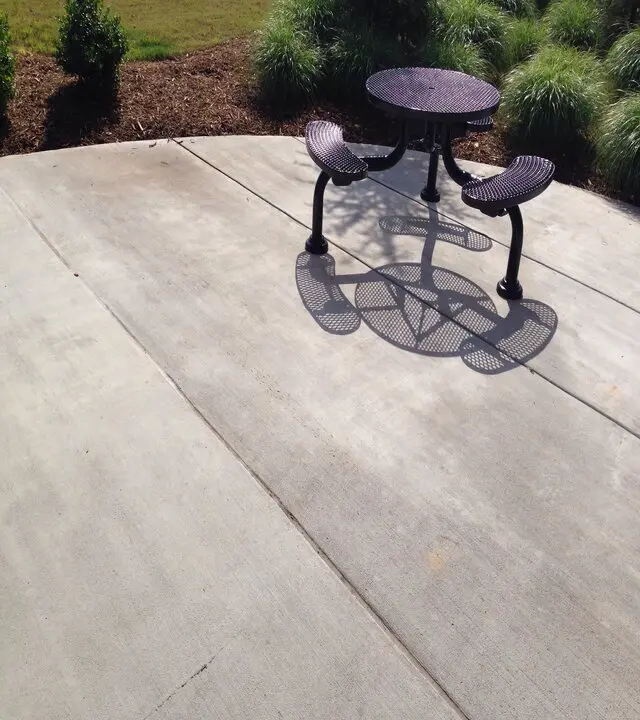 metal table on a concrete patio line joints separated in Calgary