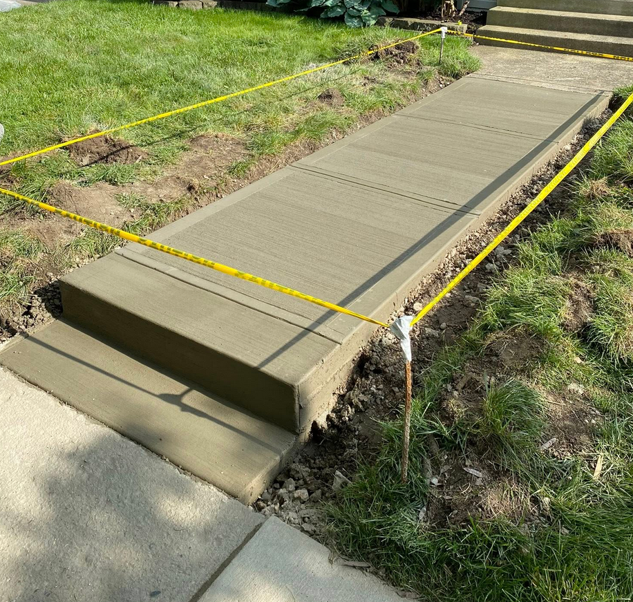 Freshly finished concrete walkway with control joints connecting to sidewalk in Calgary by Concrete Star